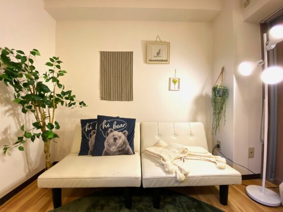 白の壁には絵や観葉植物が飾られており、ソファには可愛らしいクッションがあり、まさに 一人暮らし の空間イメージにピッタりです